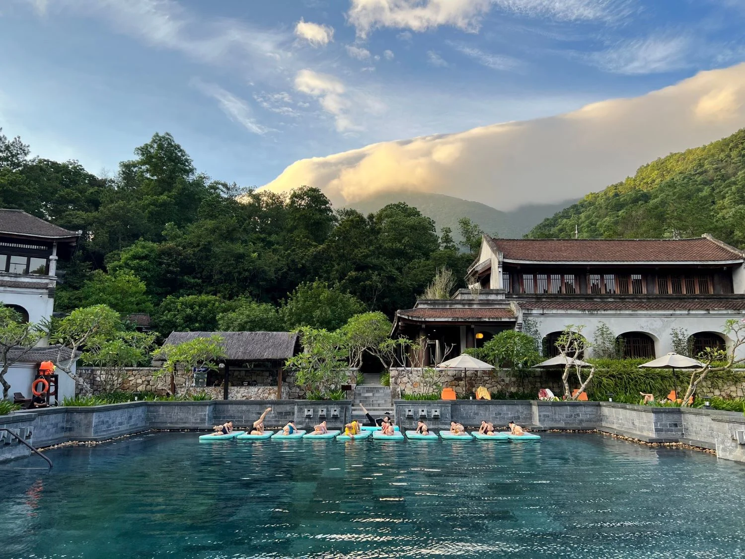 Morning yoga on the pool at Legacy Yên Tử, mountain valley and cloud above