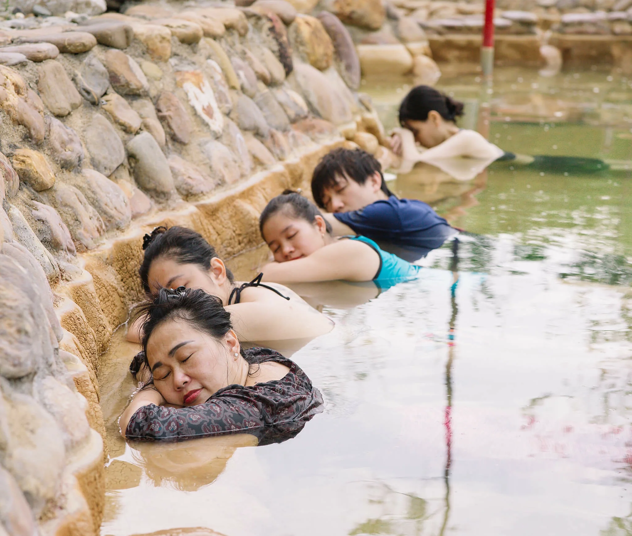 Guests resting quietly in the mineral hot spring at Alba Wellness Valley Hue during the Yên Retreat