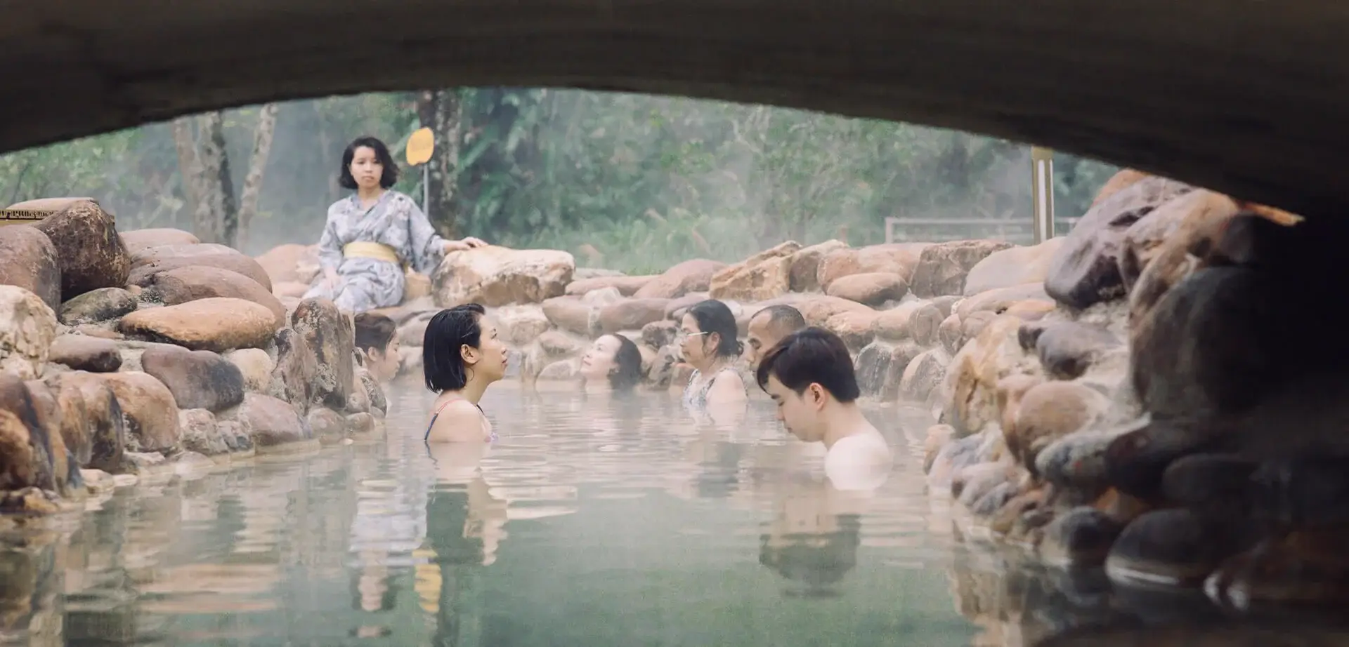 Guests resting quietly in the misty mineral hot spring at Alba Wellness Valley Hue